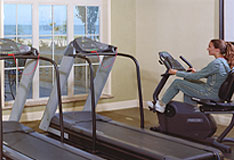 This is a picture of the exercise room. There is a guest exercising on the bike machine.
